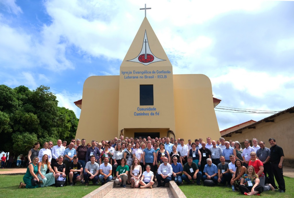 Grupo de pessoas posando para foto em frente a IECLB