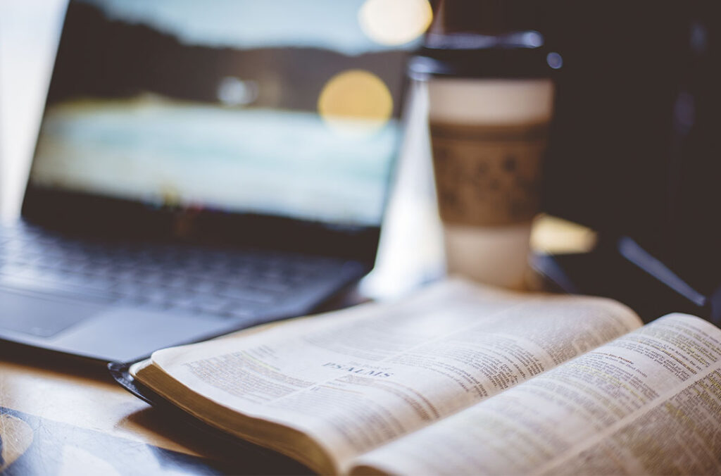 Notebook, cafe e bíblia aberta