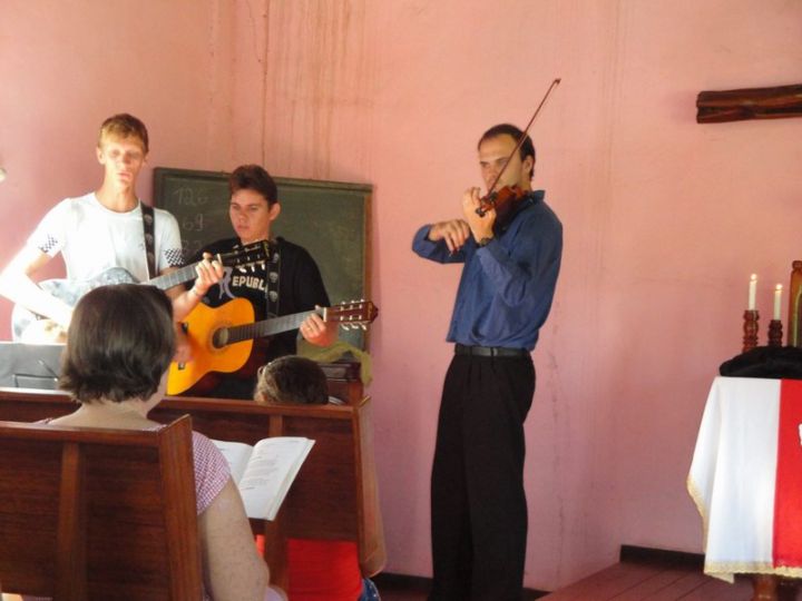 P. Tiago toca violino acompanhado por adolescentes da comunidade