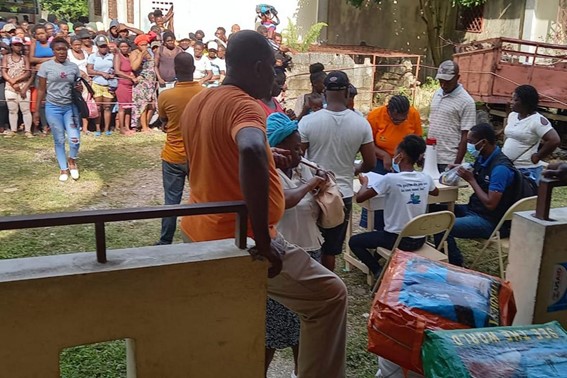 A equipe dos escritórios da Diakonie Katastrofenhilfe / FLM / Ajuda da Igreja da Noruega distribui kits de abrigo de emergência em Camp Perrin