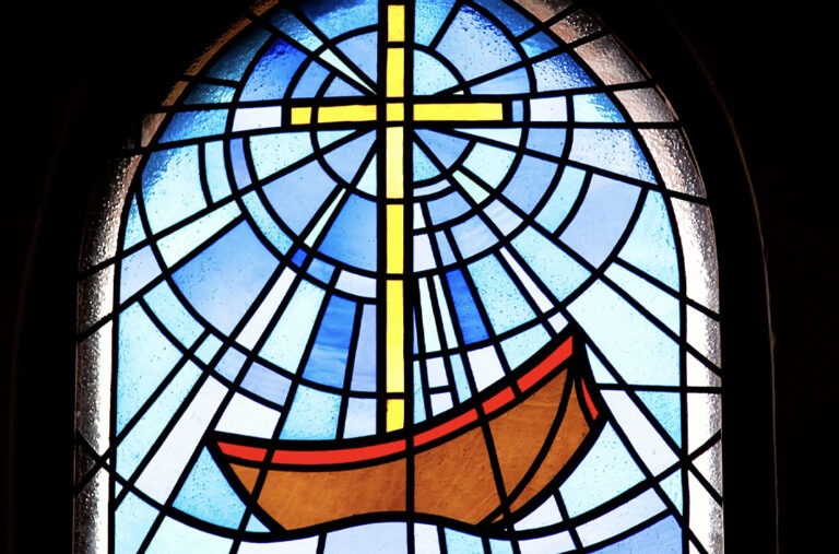 Vitral representando um barco navegando e uma Cruz acima dele